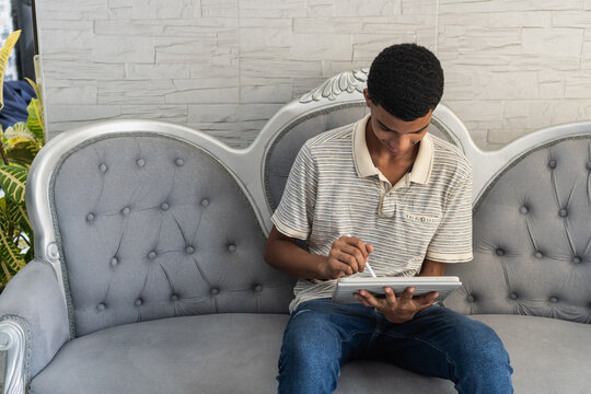 Teenager drawing digital art using stylus on tablet