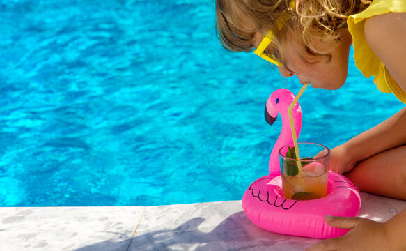 Child with juice in the pool. Selective focus.