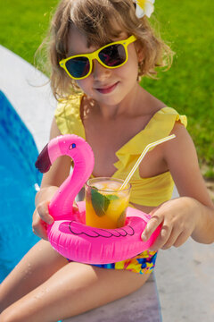 Child with juice in the pool. Selective focus.