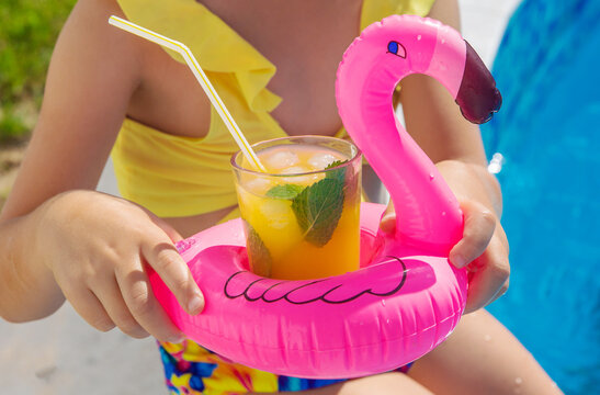 Child with juice in the pool. Selective focus.