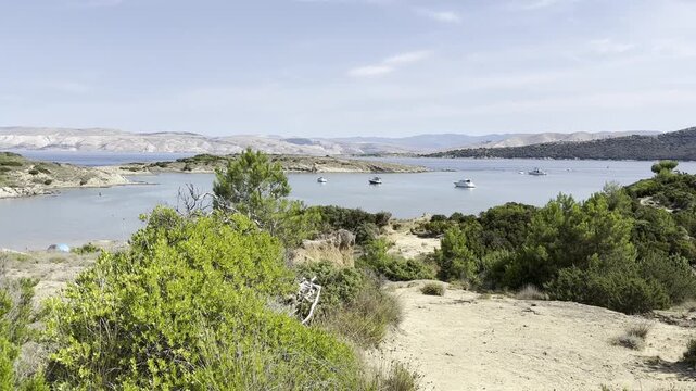 Beautiful scenic view of Ciganka Bay near Lopar on the island of Rab, Croatia. The video shows the entire picturesque bay with numerous boats anchored in the clear Adriatic Sea.