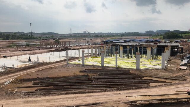 A vast land development site for a large scale terraced house project. Cleared land is prepared for new housing units. Nearby areas show ongoing residential construction in progress.