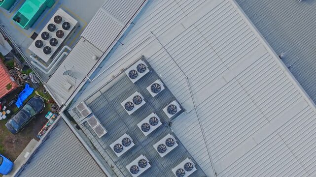 Drone shot of a modern data center rooftop featuring multiple industrial HVAC units, metallic structures, and clean geometry under daylight. Static, overhead composition highlights technology.