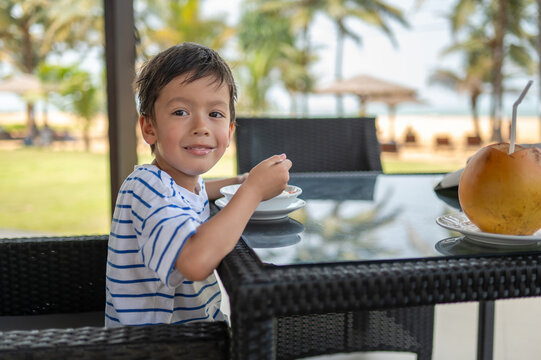 Multiracial boy enjoying breakfast at a seaside caf&eacute; in Sri Lanka