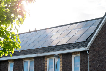 Fototapeta premium Residential Rooftop Solar Panels on Modern Home in Bright Sunlight