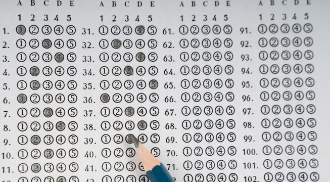 Hand points to numbered grid of black and white circles. Grid shows rows labeled with letters and numbers. Each circle is filled or empty, forming a pattern. Fingers gesture toward specific entries