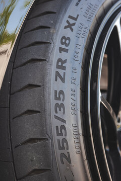 Close up view of 255 35 ZR 18 XL metric size specifications molded on low profile performance car tire sidewall.