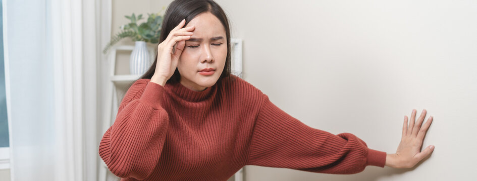 A woman is feeling dizzy and losing balance while standing.