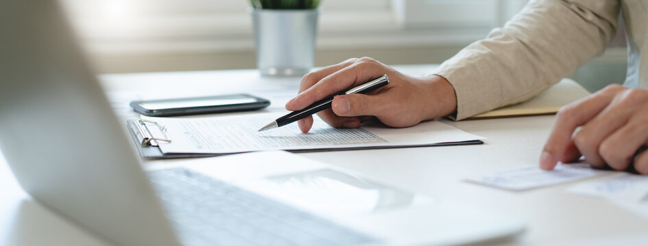 Deduction planning, debt asian accountant hand using calculator to calculating money balance from bill and income, cost budget expenses for pay money form personal individual on table at home.