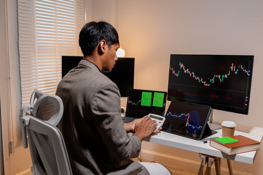 Professional stock trader reviewing market charts with sticky notes across multiple monitors, laptop, and tablet to analyze price trends, plan trading strategies, and manage investment decisions.