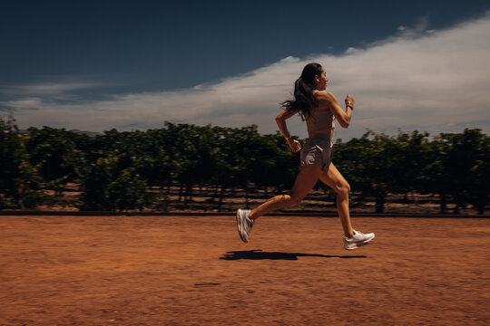 Young Woman Running Through a Park, Outdoor Fitness and Healthy Lifestyle