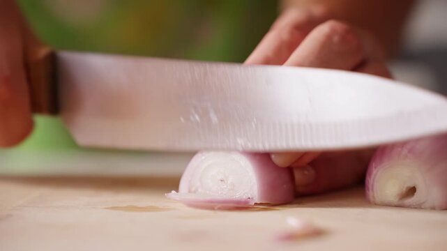 Hand Slices Fresh Shallot with Knife on Wooden Cutting Board, Detailed Food Preparation for Healthy Home Cooking Slow motion