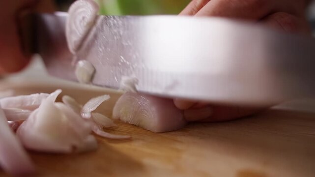 Hands Slice Fresh Shallot With a Kitchen Knife on a Wooden Board, Close Up View of Food Preparation for Homemade Cooking and Fresh Ingredients Slow motion