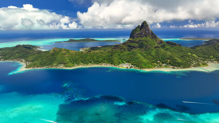 Fototapeta premium Luxury resort photo of French Polynesia tropical paradise island Bora Bora in Pacific Ocean. Beautiful photography with sandy beach, palm trees, coral reef, azure ocean, sky with clouds on horizon. 