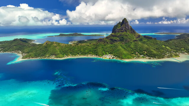 Luxury resort photo of French Polynesia tropical paradise island Bora Bora in Pacific Ocean. Beautiful photography with
sandy beach, palm trees, coral reef, azure ocean, sky 
with clouds on horizon. 