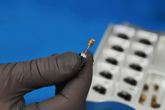 a dental instrument for working with a dental implant, which the doctor holds in a glove.