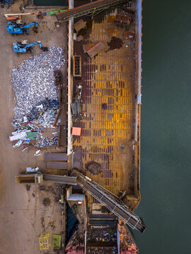 Aerial view of the Agnesberg scrap metal site in Gothenburg, featuring a large barge being loaded with industrial waste and scrap metal, Gothenburg, Vastra Gotaland County, Sweden.