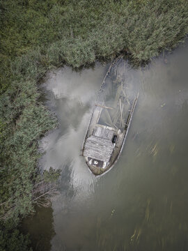 Aerial view of a sunken wooden boat resting in the shallow waters of the river near Agnesberg, Gothenburg, Vastra Gotaland County, Sweden.