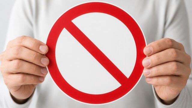 Person holding prohibition sign with red no symbol representing restriction warning regulation and safety concept