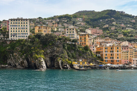 Scenic view of colorful traditional houses perched on a rocky cliff overlooking the turquoise sea in Camogli, Liguria, Italian Riviera, Italy
