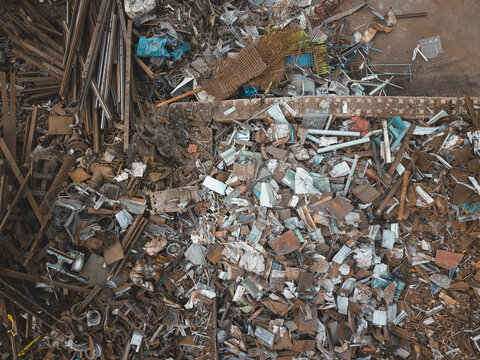 Aerial view of a large scrap metal recycling yard in Agnesberg, featuring piles of rusted metal, industrial debris, and sorted scrap materials in Gothenburg, Vastra Gotaland Count, Sweden.