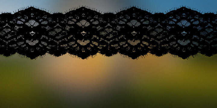 Black floral lace fabric trim isolated on a colorful soft blurry gradient background.
