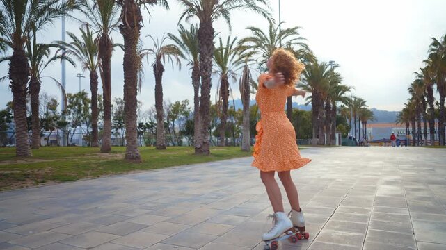 Beautiful red haired young woman with rollerskates having fun outdoors