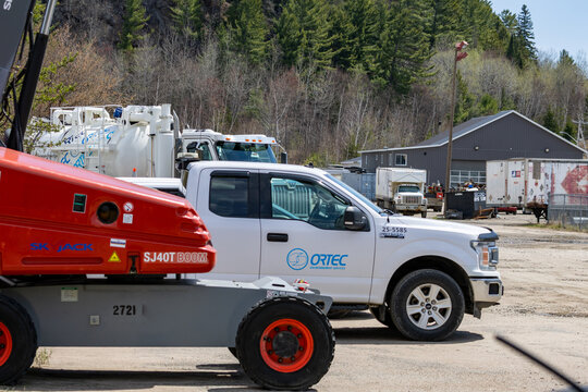 La Tuque, Quebec, 16 May 2026 : A Skyjack SJT Boom lift and an ORTEC Environnement Services Ford F- pickup truck are parked at an industrial site.