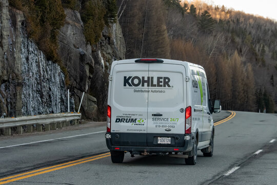 Quebec, Canada, 24 April 2026 : A white Ford Transit van with Kohler and Drum Co branding drives on a winding road.