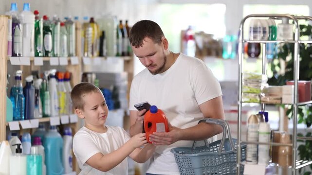 Dad and son scan barcode on packaging of sewer cleaner liquid. High quality 4k footage