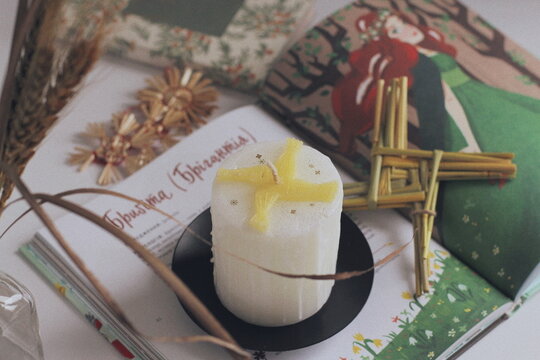 white candle with a Brigid's cross for Imbolc