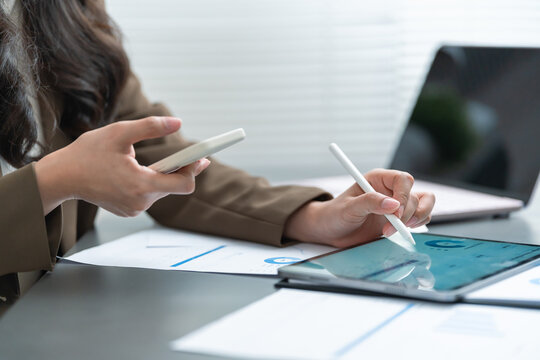 Businesswoman uses a tablet and smartphone to review dashboards and business reports, highlighting data analytics, digital workflow, financial planning, and productivity.
