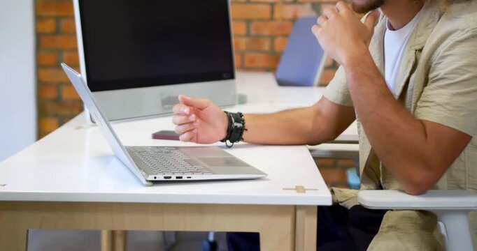 Taking call man at office answering donning headphones leaning into laptop joining call, copy space