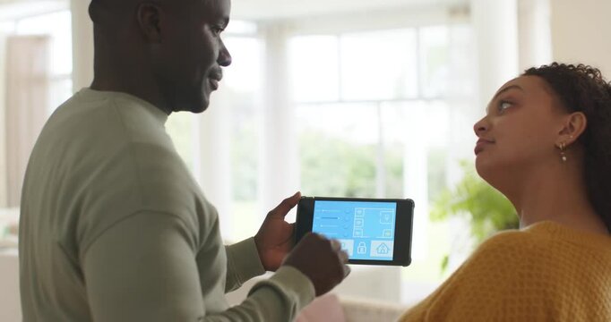 African American couple watching man tapping tablet, starting demo blue smart home UI, high-fiving