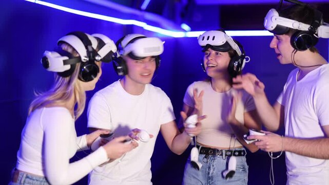 Group of friends chat animatedly after playing virtual reality. Participants share their impressions and discuss plot of adventure travel adventure in parallel reality.