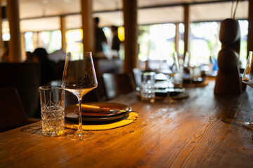 Elegant restaurant interior with cozy seating and warm lighting. A table served for celebration or wine party at a bar or restaurant. © Mykola