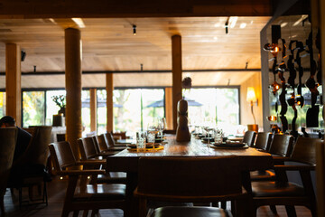 Elegant restaurant interior with cozy seating and warm lighting. A table served for celebration or wine party at a bar or restaurant. © Mykola