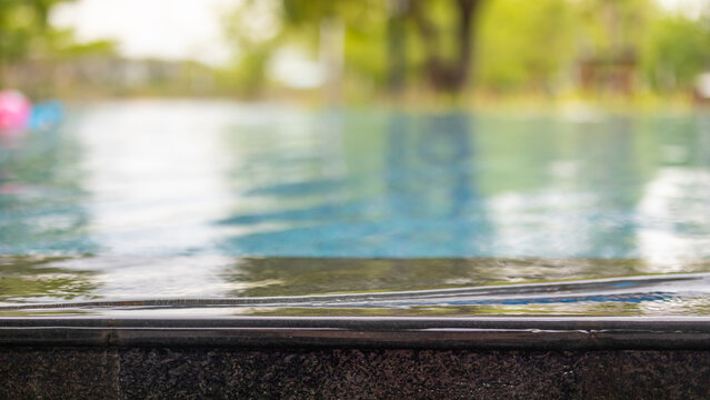 Empty stone edge of swimming pool with blurred background for product display