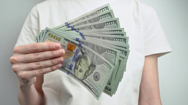 Female hands counting stack of dollar banknotes isolated on white background. Cash payment, savings, financial planning, investment and money management concept.	
