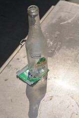 Fototapeta premium discarded Mexican soft-drink Jarritos bottle in Toronto (on a flat packet wrapper of gum)