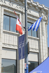Fototapeta premium flags of Canada and Greece with banner in Greek Town near RBC Royal Bank 650 Danforth Av, Toronto