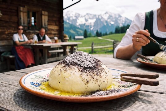 Traditioneller &ouml;sterreichischer Germkn&ouml;del mit Mohn und geschmolzener Butter auf einer Almh&uuml;tte in den Alpen.