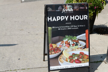Fototapeta premium a-frame sidewalk sign outside Fresh Kitchen + Juice Bar, a vegan restaurant, located at 320 Danforth Av, Carrot Common, Toronto