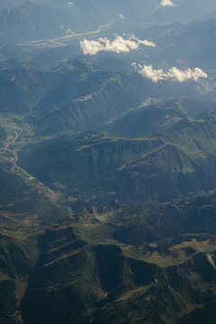 Swiss Alps mountain landscape with winding river and rugged valley seen from airplane, Switzerland
