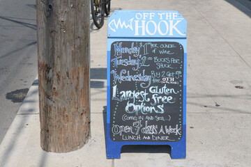 Fototapeta premium chalkboard sidewalk sign outside Off The Hook Fishbar, a fish & chips restaurant, located at 749 Broadview AV, Toronto