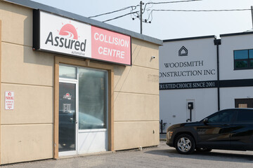 Fototapeta premium exterior building facade and sign of Assured Automotive, an auto body shop, located at 90 Wicksteed Av, East York, Toronto