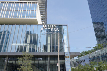 Fototapeta premium exterior building facade and sign of UNITY Fitness Harbourfront, a gym, located inside Sugar Wharf Condominiums, located at 120 Downes St, Toronto