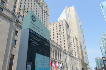 Fototapeta premium wayfinding sign and a defocused view of the Châteauesque Fairmont Royal York hotel, and the south tower of Royal Bank Plaza, Toronto