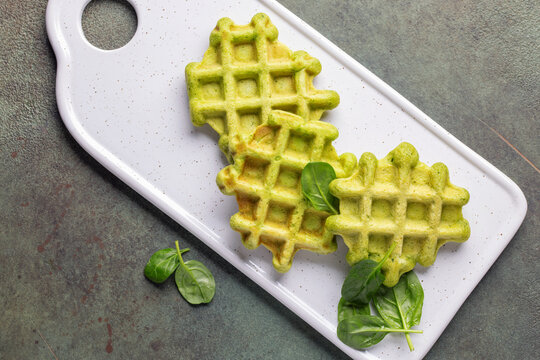 Delicious vegan spinach waffles in plate. Top view