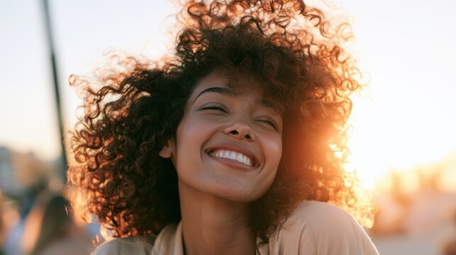 Portrait of a smiling young African woman at sunset in warm golden hour light
